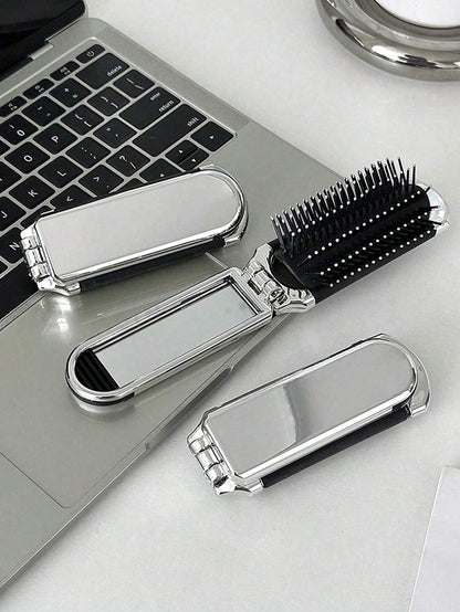 A Shiny Electroplated Silver Comb With A Foldable Design, A Small Mirror, Compact And Portable