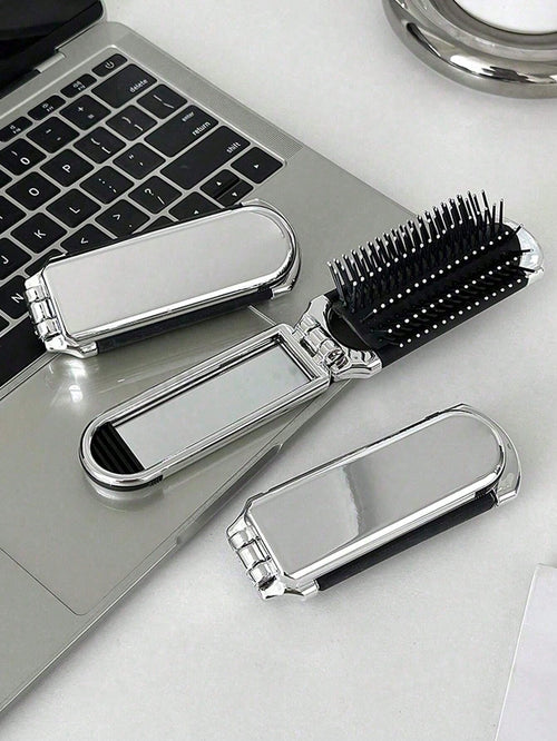 A Shiny Electroplated Silver Comb With A Foldable Design, A Small Mirror, Compact And Portable