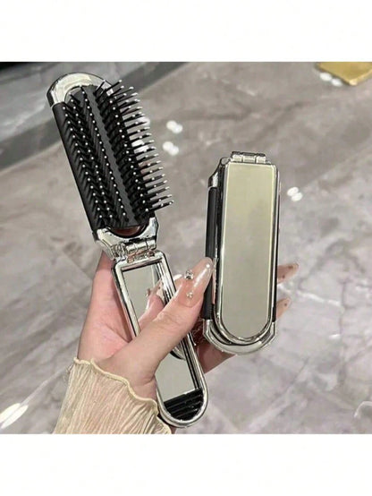 A Shiny Electroplated Silver Comb With A Foldable Design, A Small Mirror, Compact And Portable